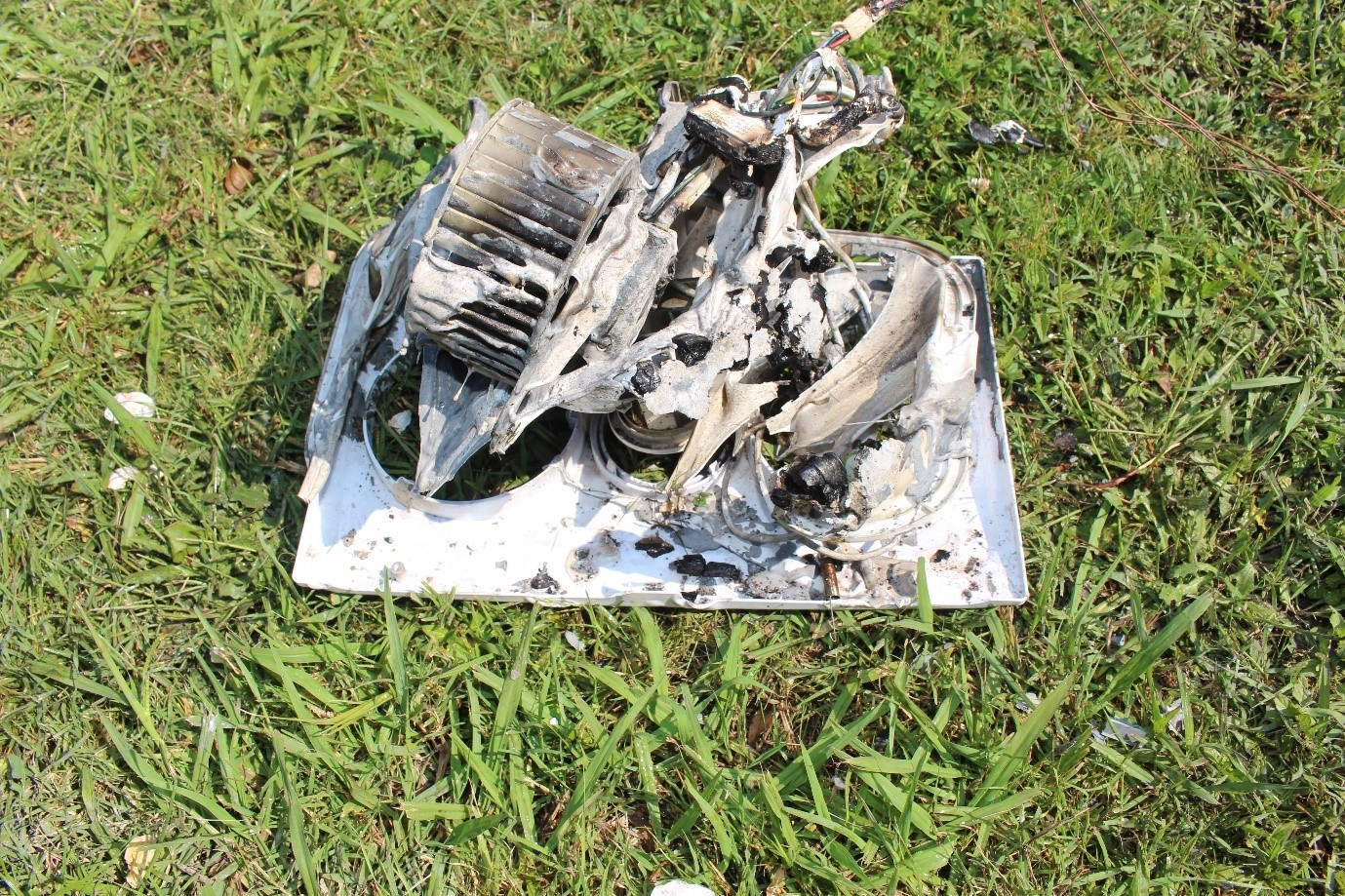 [image] a bathroom fan/light combo with substantial fire damage unit lying on the grass. 