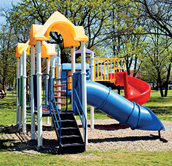 [image] Children's playground structure with stairs, railing, climbing platforms, tube slide and open slide.