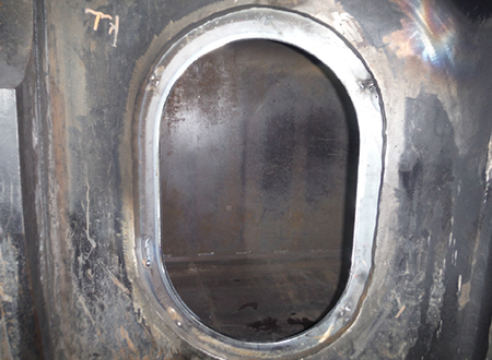 [image] Oval shaped inspection window on outside of gray steel box section