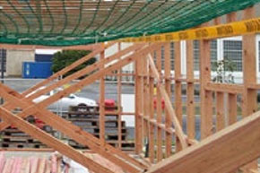 [image] Temporary timber bracing beneath a mesh safety net